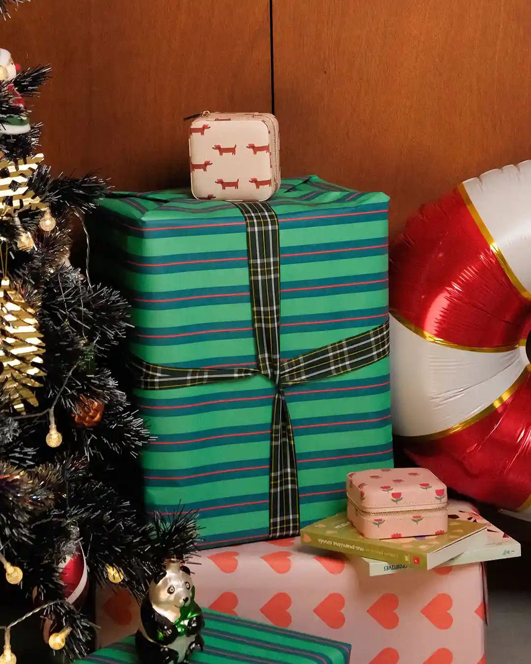 Cadeaux de noel à côté d'un sapin et deux boites à bijoux à motifs