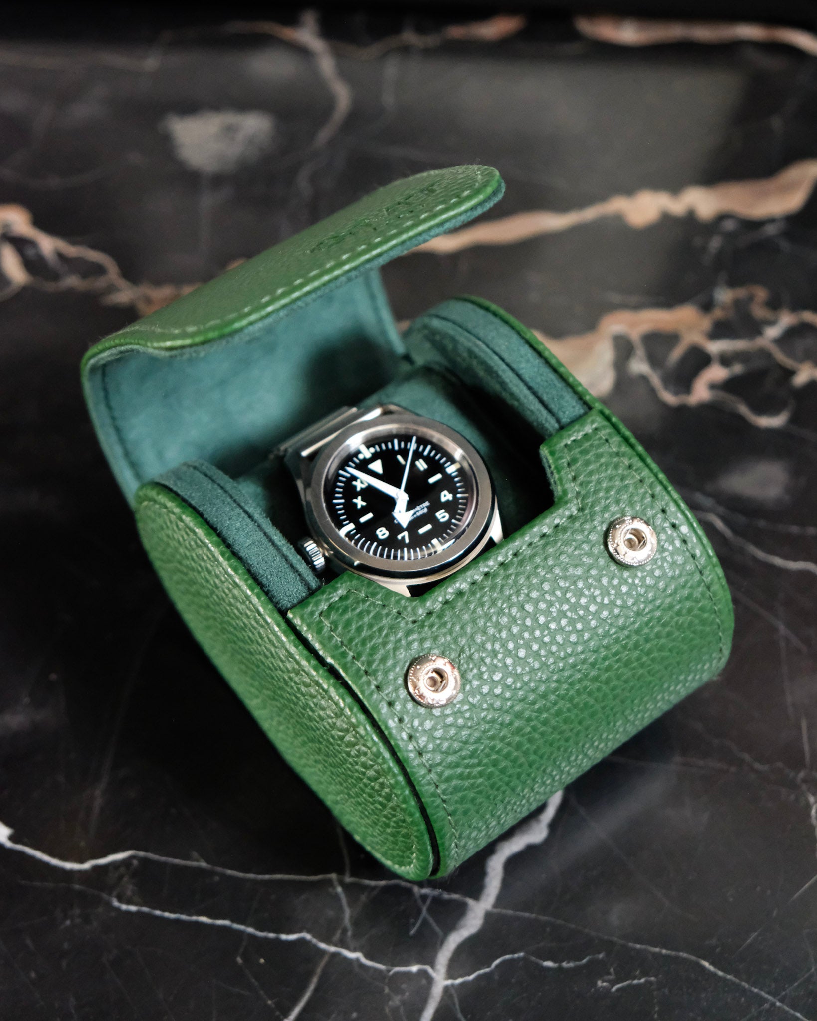 boite pour une seule montre verte, ouverte, vue du dessus avec une montre à l'intérieur