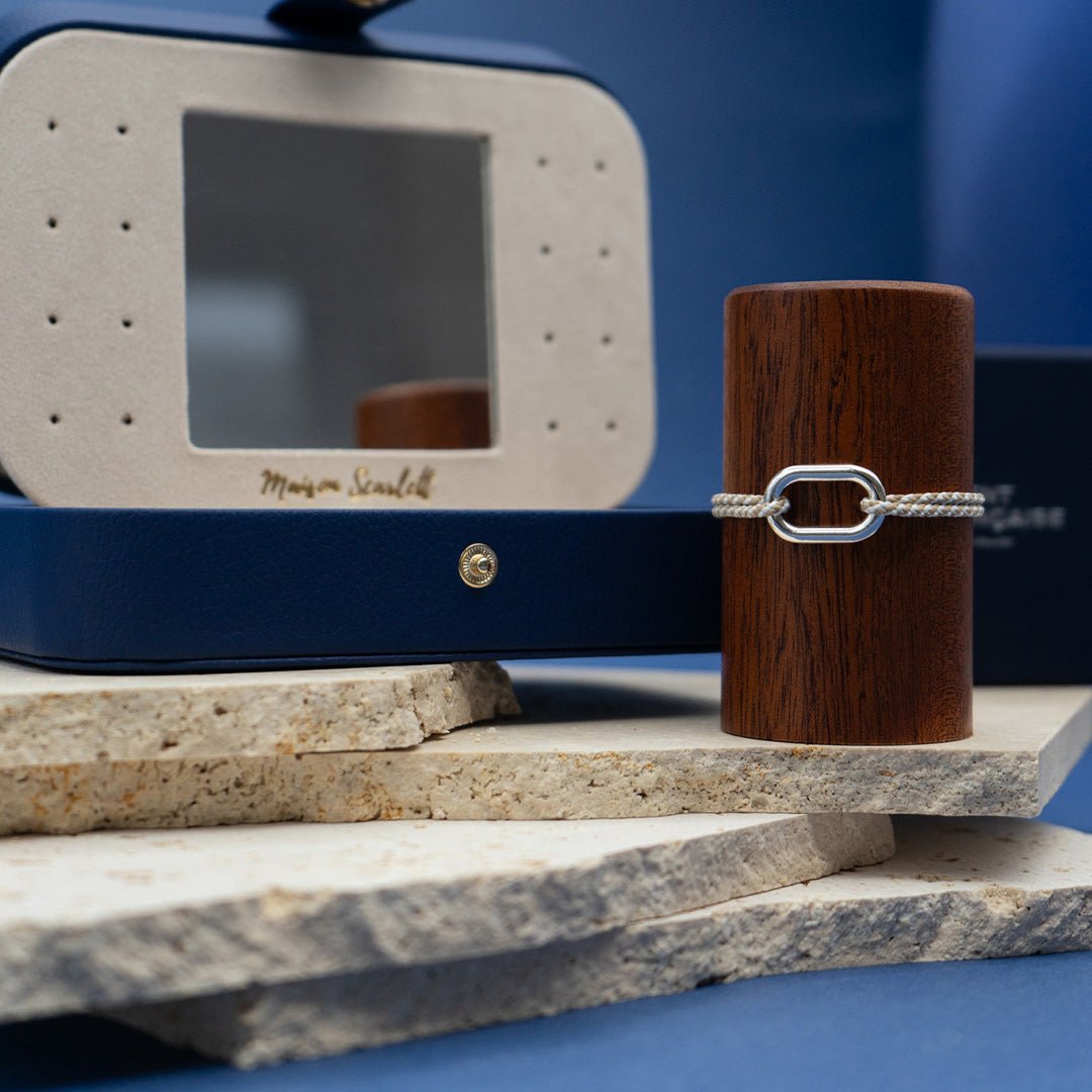 bracelet avec en fond la boite à bijoux bleu marine en cuir pu